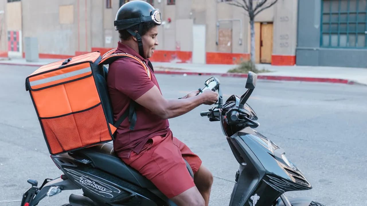Repartidor urbano con mochila de entrega y motocicleta