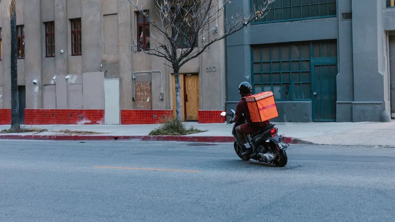 Repartidor de delivery conduciendo una motocicleta